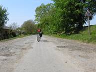 Ukraińska rowerostrada: środkiem asfaltowy dywanik, po bokach dziury spowalniające ruch samochodowy.